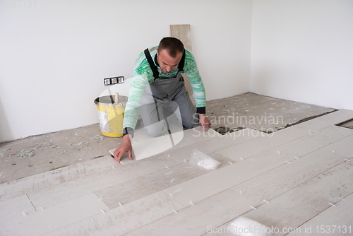 Image of worker installing the ceramic wood effect tiles on the floor