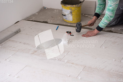 Image of worker installing the ceramic wood effect tiles on the floor