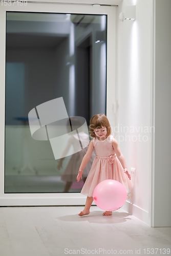 Image of cute little girl playing with balloons