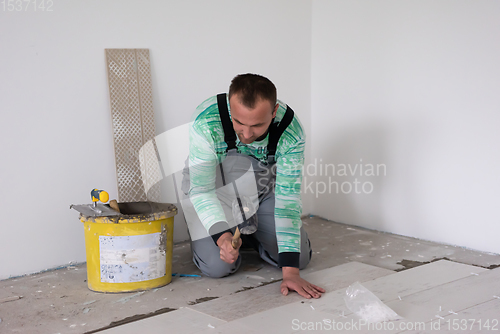 Image of worker installing the ceramic wood effect tiles on the floor