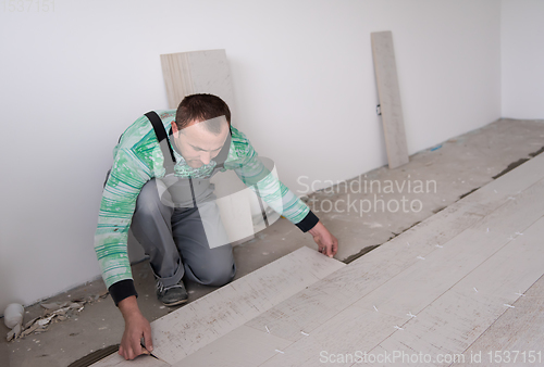 Image of worker installing the ceramic wood effect tiles on the floor