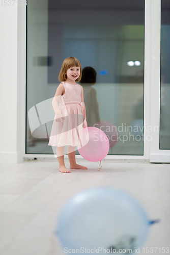 Image of cute little girl playing with balloons