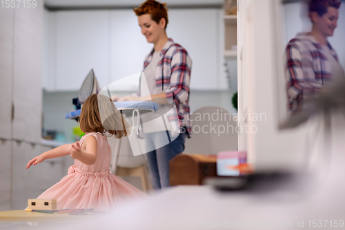 Image of mother and little daughter spending time together at home