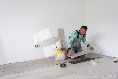 Image of worker installing the ceramic wood effect tiles on the floor