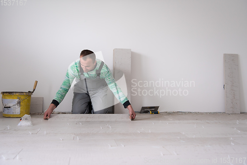 Image of worker installing the ceramic wood effect tiles on the floor