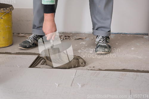 Image of worker installing the ceramic wood effect tiles on the floor