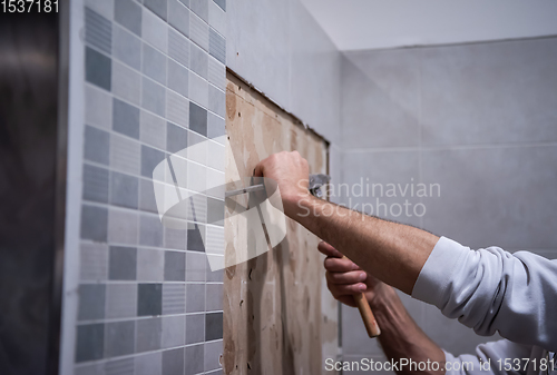 Image of worker remove demolish old tiles in a bathroom