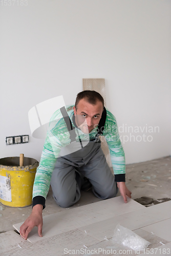 Image of worker installing the ceramic wood effect tiles on the floor