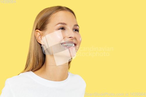 Image of Caucasian young woman\'s half-length portrait on yellow background