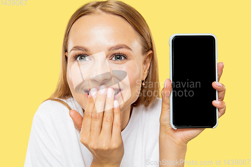 Image of Caucasian young woman\'s half-length portrait on yellow background