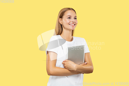 Image of Caucasian young woman\'s half-length portrait on yellow background