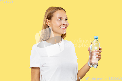 Image of Caucasian young woman\'s half-length portrait on yellow background