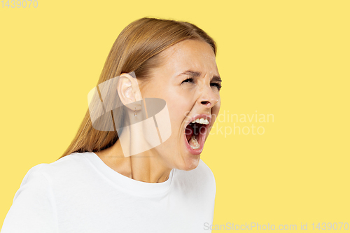 Image of Caucasian young woman\'s half-length portrait on yellow background