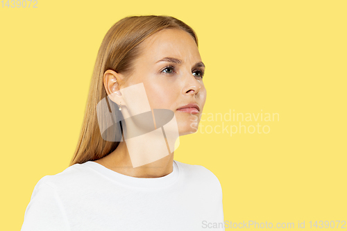 Image of Caucasian young woman\'s half-length portrait on yellow background