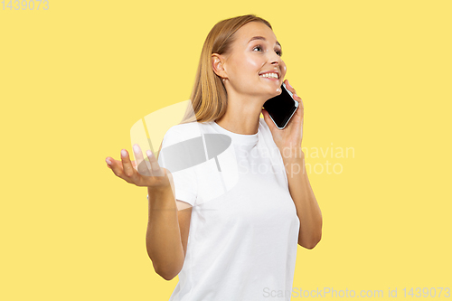 Image of Caucasian young woman\'s half-length portrait on yellow background