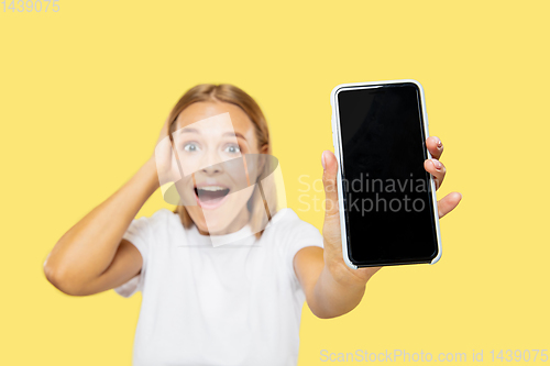 Image of Caucasian young woman\'s half-length portrait on yellow background