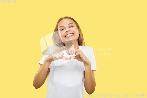 Image of Caucasian young woman\'s half-length portrait on yellow background