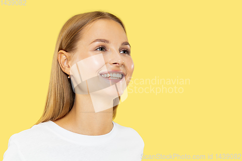 Image of Caucasian young woman\'s half-length portrait on yellow background