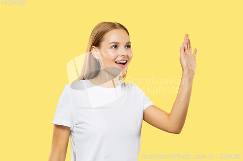 Image of Caucasian young woman\'s half-length portrait on yellow background