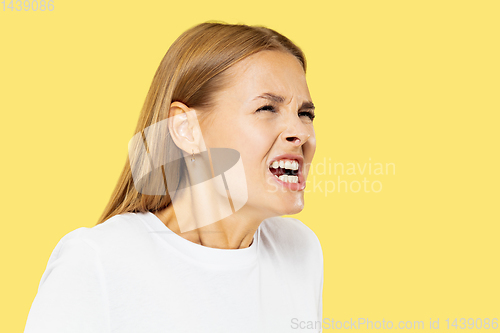 Image of Caucasian young woman\'s half-length portrait on yellow background