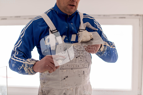 Image of construction worker plastering on gypsum walls