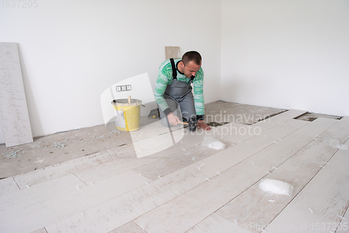 Image of worker installing the ceramic wood effect tiles on the floor