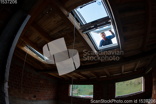 Image of construction worker installing roof window