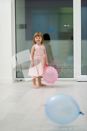 Image of cute little girl playing with balloons