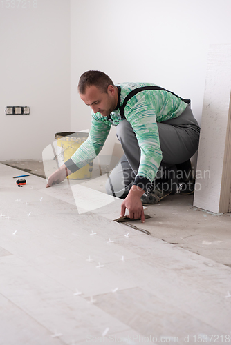 Image of worker installing the ceramic wood effect tiles on the floor
