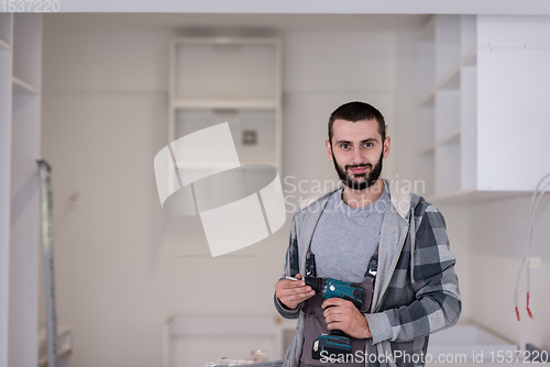 Image of the worker holding a hand drilling machine