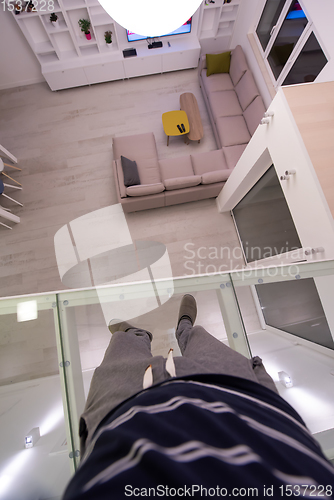 Image of man standing upstairs on glass floor