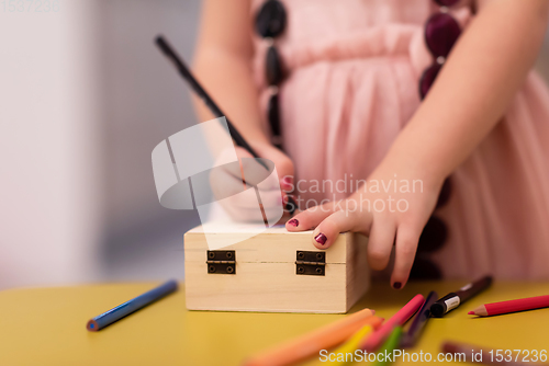 Image of little girl painting jewelry box