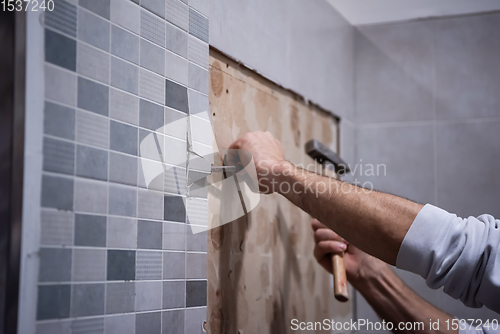 Image of worker remove demolish old tiles in a bathroom