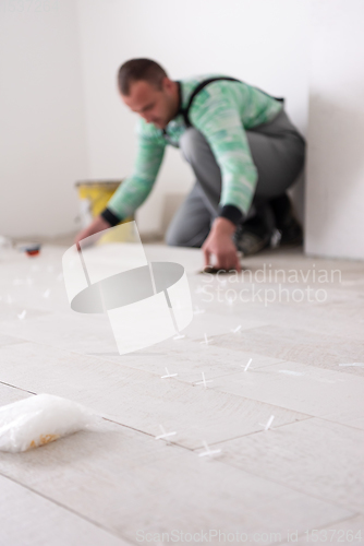 Image of worker installing the ceramic wood effect tiles on the floor