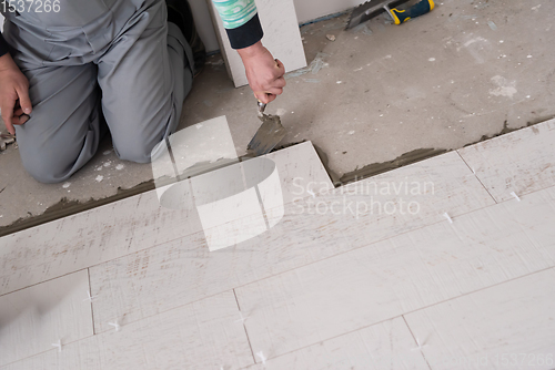 Image of worker installing the ceramic wood effect tiles on the floor