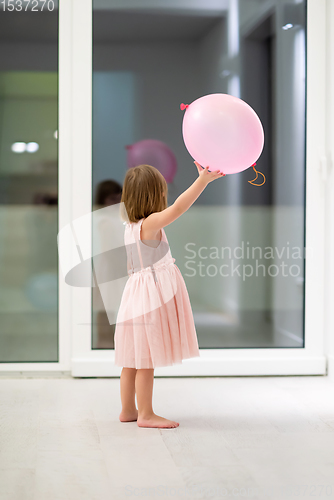 Image of cute little girl playing with balloons