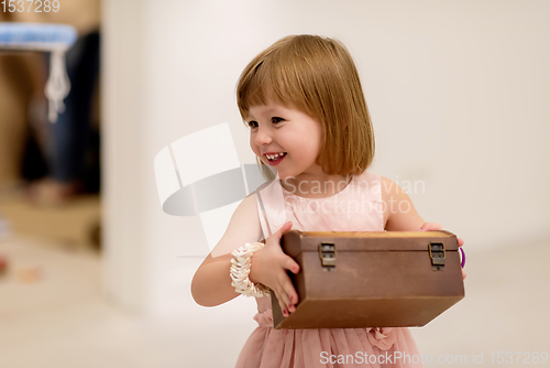 Image of little girl enjoying while playing with mother\'s jewelry