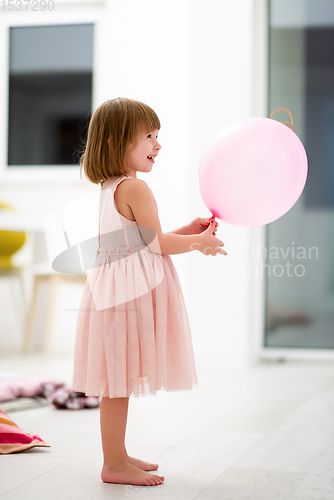 Image of cute little girl playing with balloons