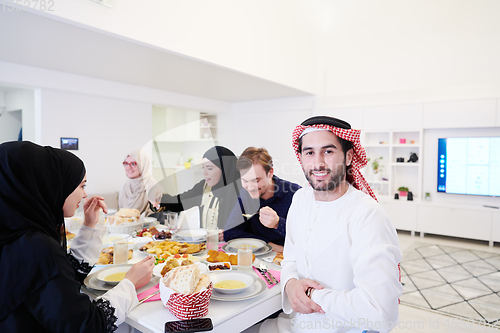 Image of young arabian man having Iftar dinner with muslim family