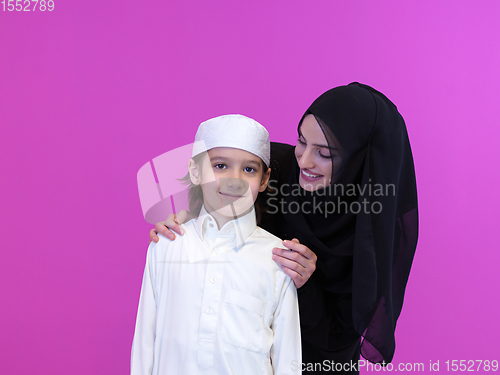 Image of portrait of muslim mother and son on pink background