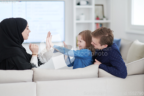 Image of Happy Muslim family having fun at home