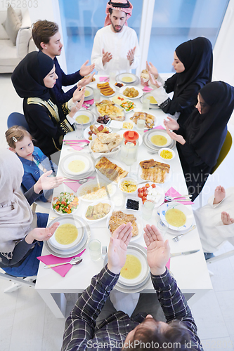 Image of traditional muslim family praying before iftar dinner