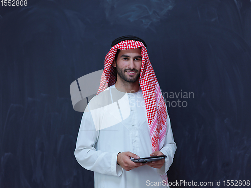 Image of young arabian muslim businessman using tablet computer