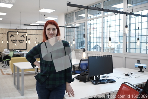 Image of redhead woman at work  in creative modern coworking startup open