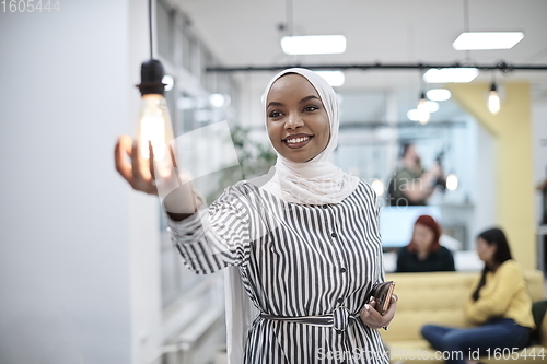 Image of internet of things concept woman holding hands around bulb