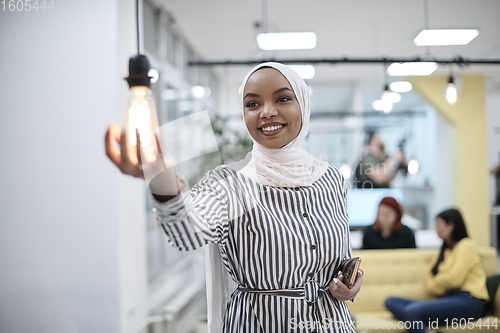 Image of internet of things concept woman holding hands around bulb