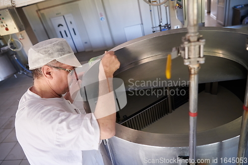 Image of Cheese production cheesemaker working in factory