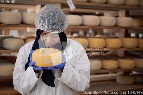 Image of African black muslim business woman in local cheese production company