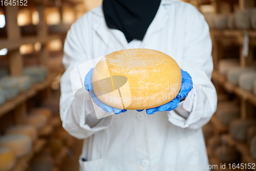 Image of African black muslim business woman in local cheese production company