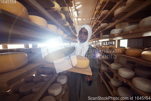 Image of African black muslim business woman in local cheese production company